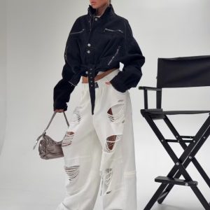 ΠΑΝΤΕΛΟΝΙ ΦΟΡΜΑΣ ΣΕ ΠΟΛΥ ΦΑΡΔΙΑ, OVERSIZED ΓΡΑΜΜΗ (BAGGY FIT). ΕΧΕΙ ΦΑΡΔΥ ΛΑΣΤΙΧΟ ΣΤΗ ΜΕΣΗ ΜΕ ΜΙΑ ΜΑΥΡΗ ΤΕΤΡΑΓΩΝΗ ΕΤΙΚΕΤΑ ΡΑΜΜΕΝΗ ΣΤΟ ΚΕΝΤΡΟ. ΕΝΤΟΝΑ ΚΑΙ ΜΕΓΑΛΑ ΣΚΙΣΙΜΑΤΑ ΣΕ ΟΛΟ ΤΟ ΜΗΚΟΣ ΣΤΑ ΜΠΑΤΖΑΚΙΑ. ΔΙΑΘΕΤΟΥΝ ΕΦΕ ΞΕΦΤΙΣΜΕΝΩΝ ΟΡΙΖΟΝΤΙΩΝ ΝΗΜΑΤΩΝ ΠΟΥ ΚΑΛΥΠΤΟΥΝ ΤΑ ΑΝΟΙΓΜΑΤΑ. ΜΑΚΡΙΑ ΜΠΑΤΖΑΚΙΑ.